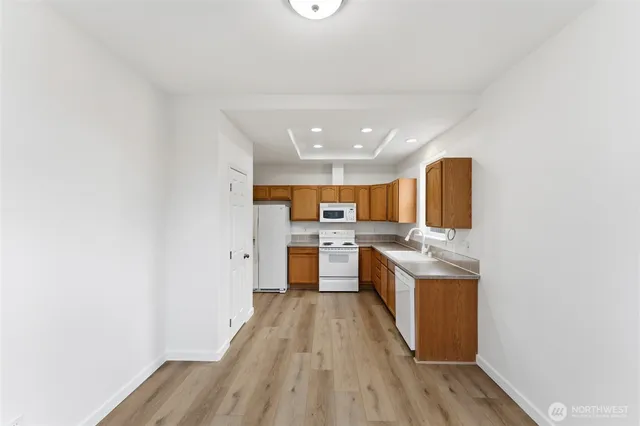 a kitchen with a sink and wooden floor
