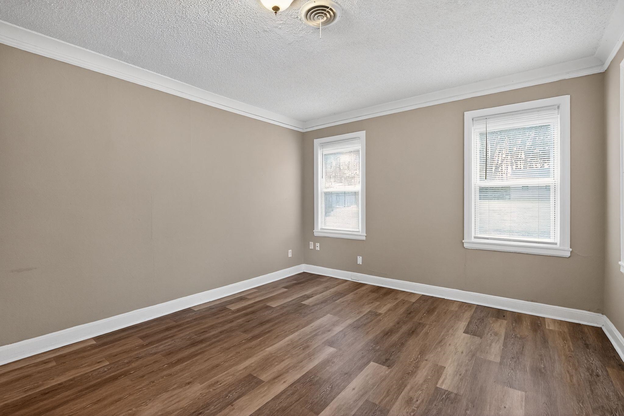 356 Hewlett Road Memphis, TN 38109 - Photo 17 of 30 an empty room with wooden floor and windows