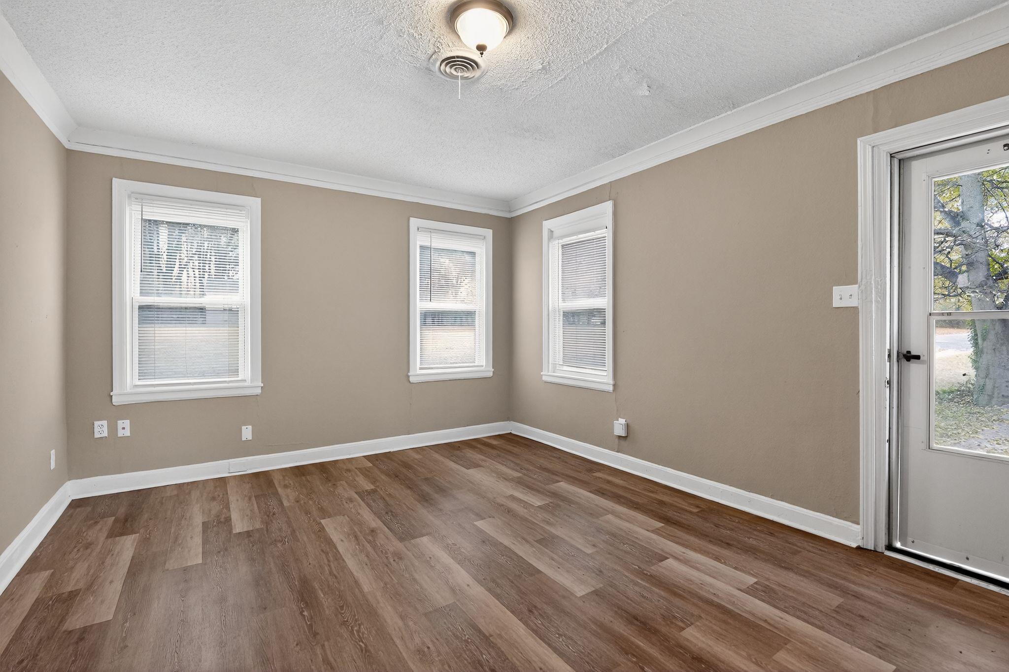 356 Hewlett Road Memphis, TN 38109 - Photo 19 of 30 an empty room with wooden floor and windows