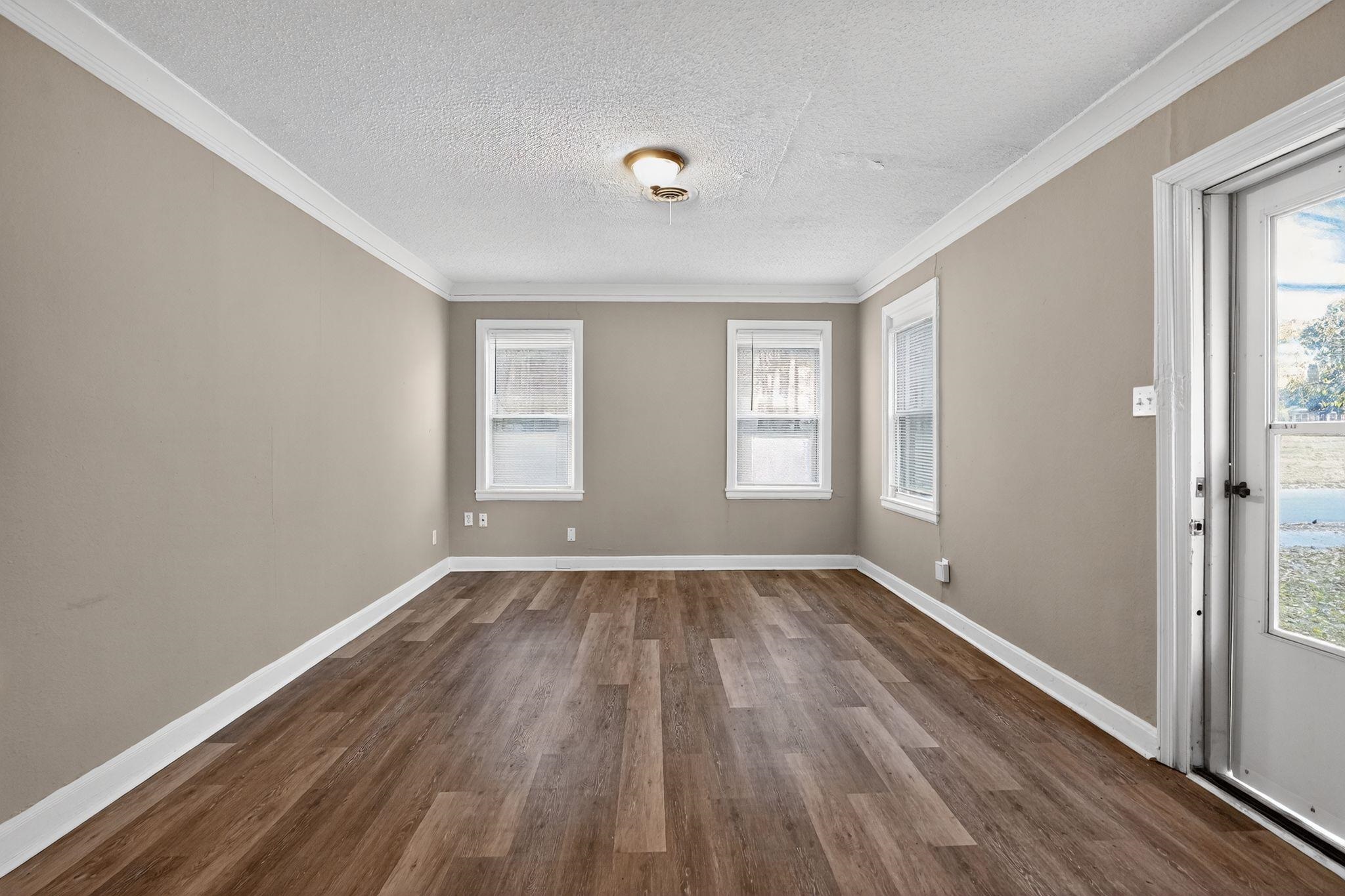356 Hewlett Road Memphis, TN 38109 - Photo 21 of 30 a view of an empty room with wooden floor and a window