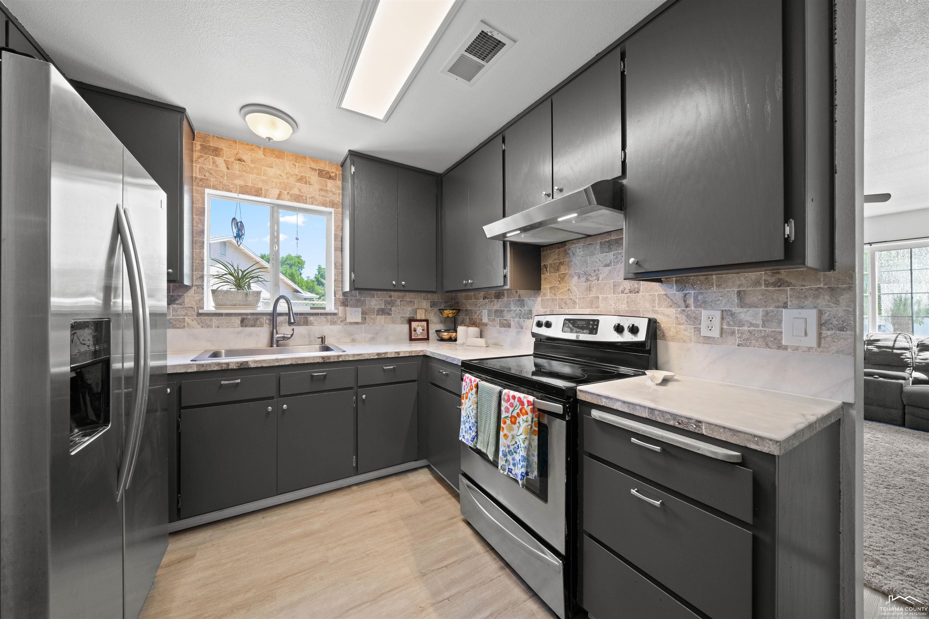 2320 Gentry Way Red Bluff, CA 96080 - Photo 2 of 11 a kitchen with stainless steel appliances granite countertop a sink stove and refrigerator