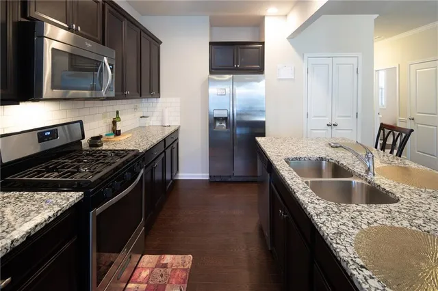 a kitchen with granite countertop a sink and steel stainless steel appliances