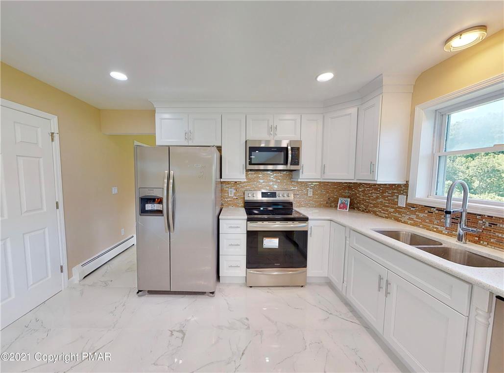 1110 Misty Ridge East Stroudsburg, PA 18302 - Photo 13 of 43 A well-appointed kitchen features stainless steel appliances, gleaming white cabinetry, and a bright window over the double sink.