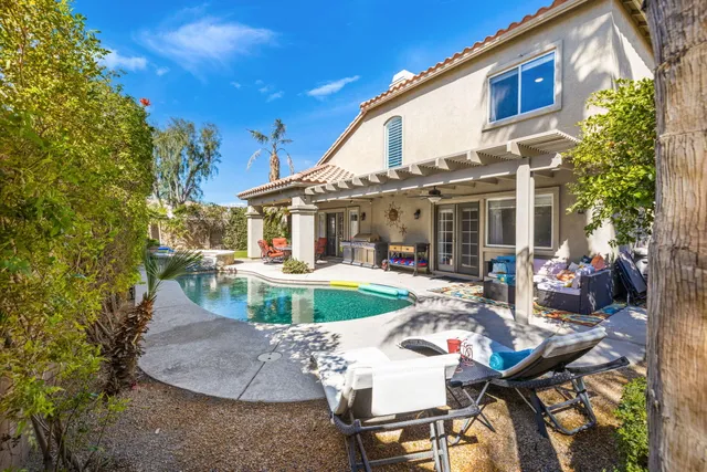 a patio with table and chairs and potted plants