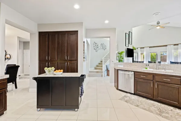 a kitchen with stainless steel appliances granite countertop a table chairs refrigerator and cabinets