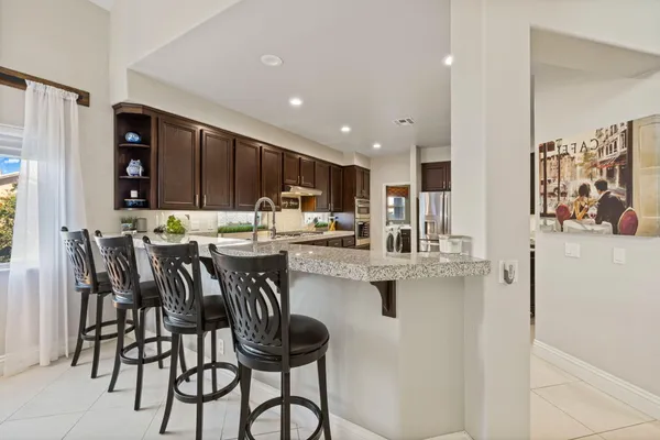 a kitchen with stainless steel appliances granite countertop a refrigerator and a sink