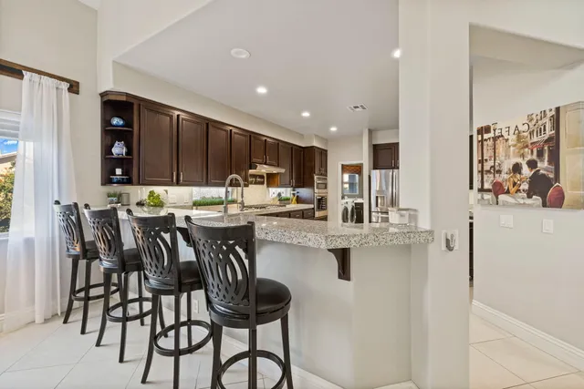 a kitchen with stainless steel appliances granite countertop a refrigerator and a sink