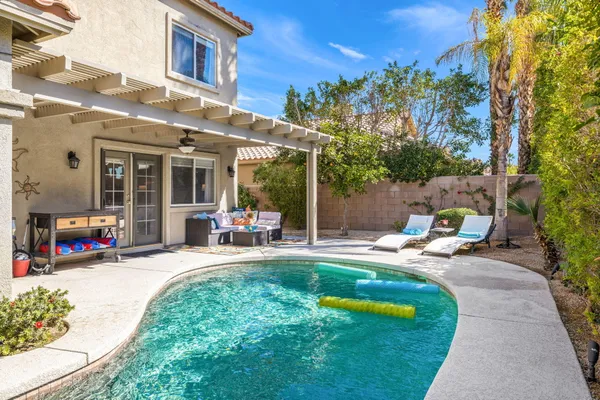a view of a chair and tables in the patio in front of the house