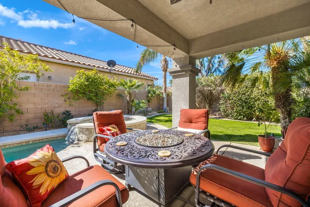 a view of a patio with a table chairs and a backyard