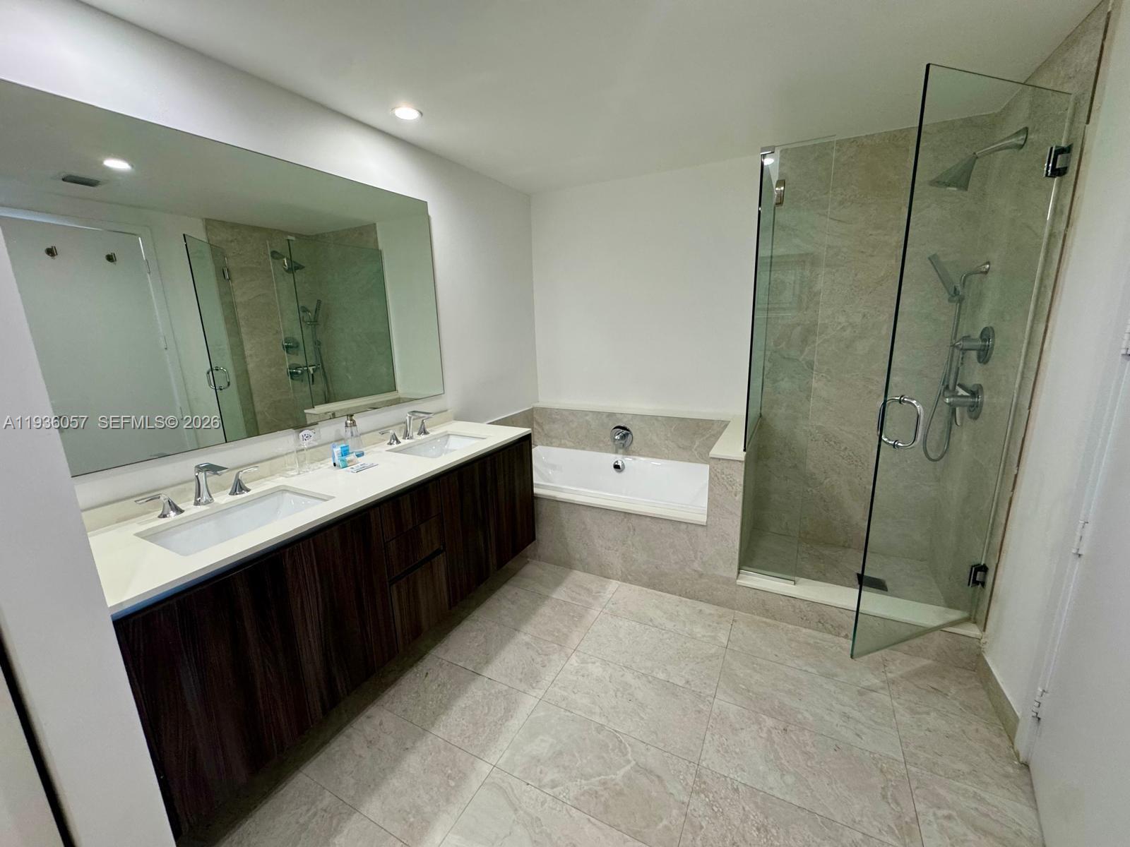 488 Northeast 18th Street, Unit 806 Miami, FL 33132 - Photo 12 of 13 a spacious bathroom with a double vanity sink mirror and bathtub