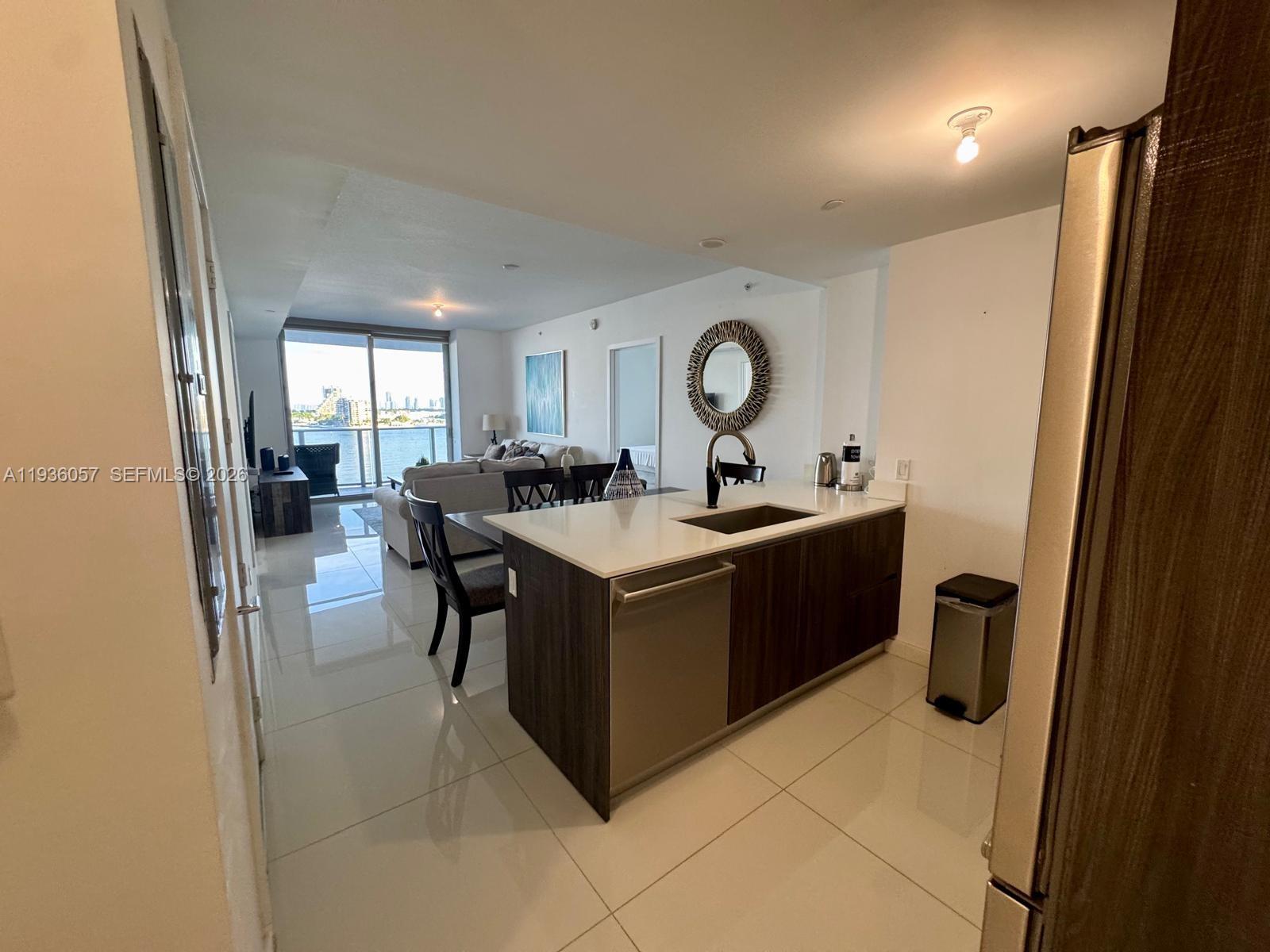 488 Northeast 18th Street, Unit 806 Miami, FL 33132 - Photo 3 of 13 a room with a sink a clock and windows