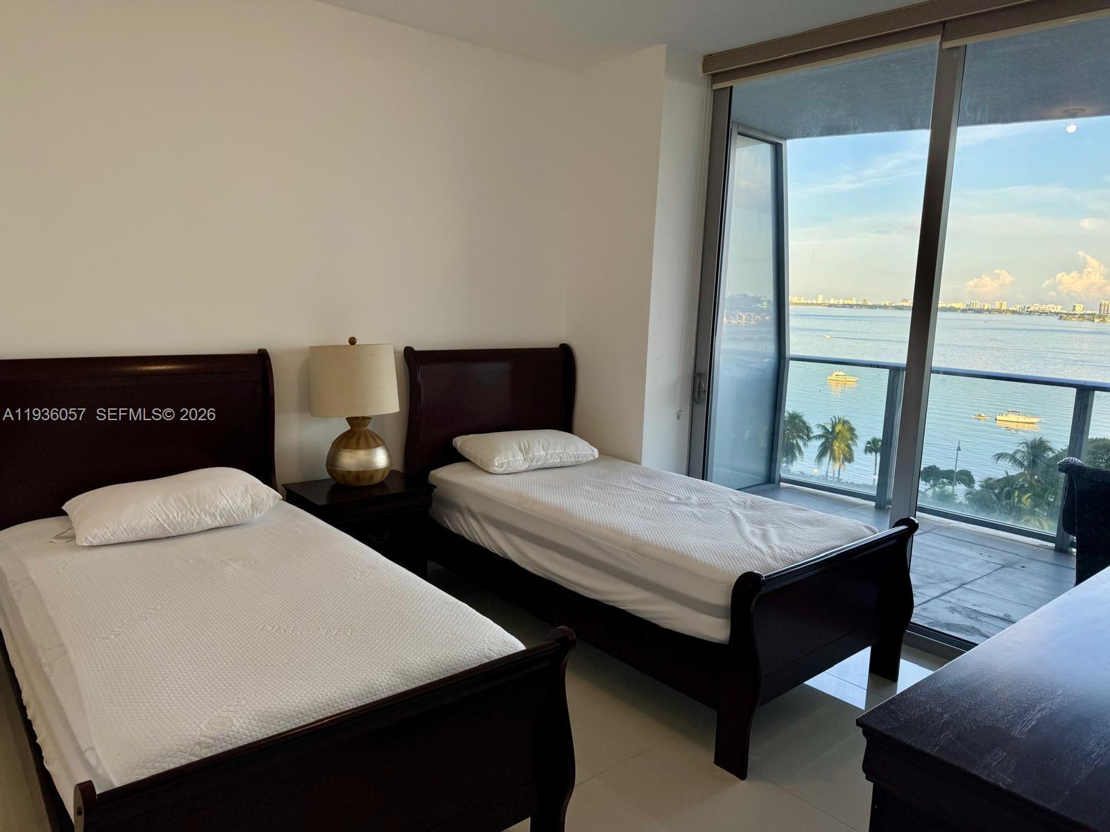 488 Northeast 18th Street, Unit 806 Miami, FL 33132 - Photo 8 of 13 a bedroom with a bed and a window