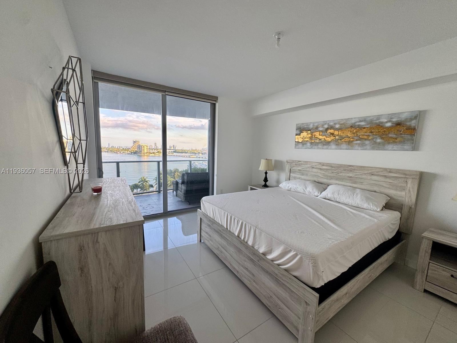 488 Northeast 18th Street, Unit 806 Miami, FL 33132 - Photo 9 of 13 a bed sitting in a bedroom next to a window