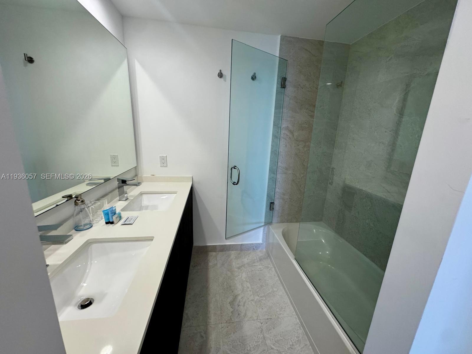 488 Northeast 18th Street, Unit 806 Miami, FL 33132 - Photo 10 of 13 a bathroom with a sink a tub and a mirror