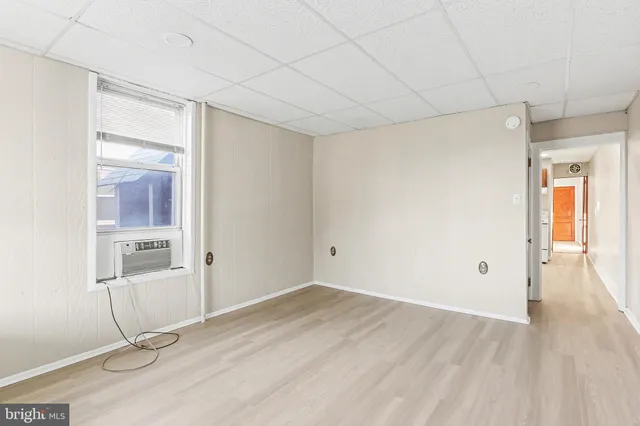 a view of a room with wooden floor and white walls