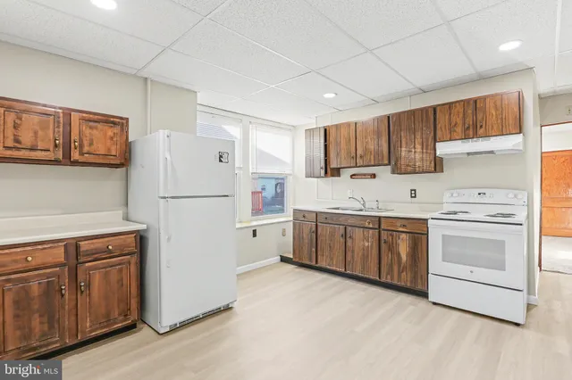 a kitchen with a refrigerator sink and cabinets