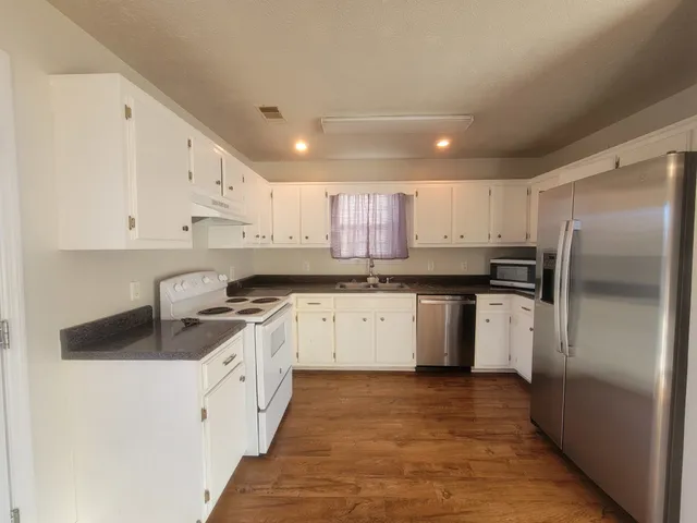 a kitchen with a refrigerator sink and cabinets