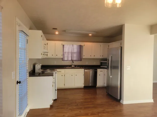 a kitchen with stainless steel appliances granite countertop a stove a sink and a refrigerator