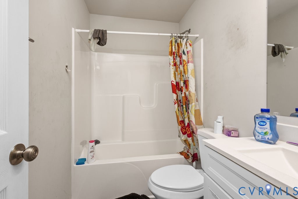 829 Rome Street Petersburg, VA 23803 - Photo 16 of 20 a bathroom with a sink a toilet and a shower curtain