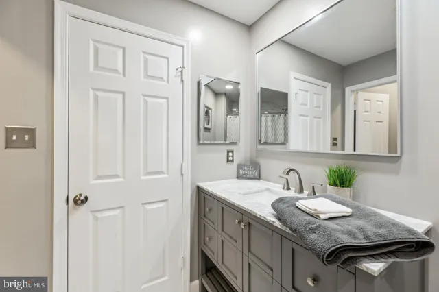 a bathroom with a granite countertop sink and a mirror