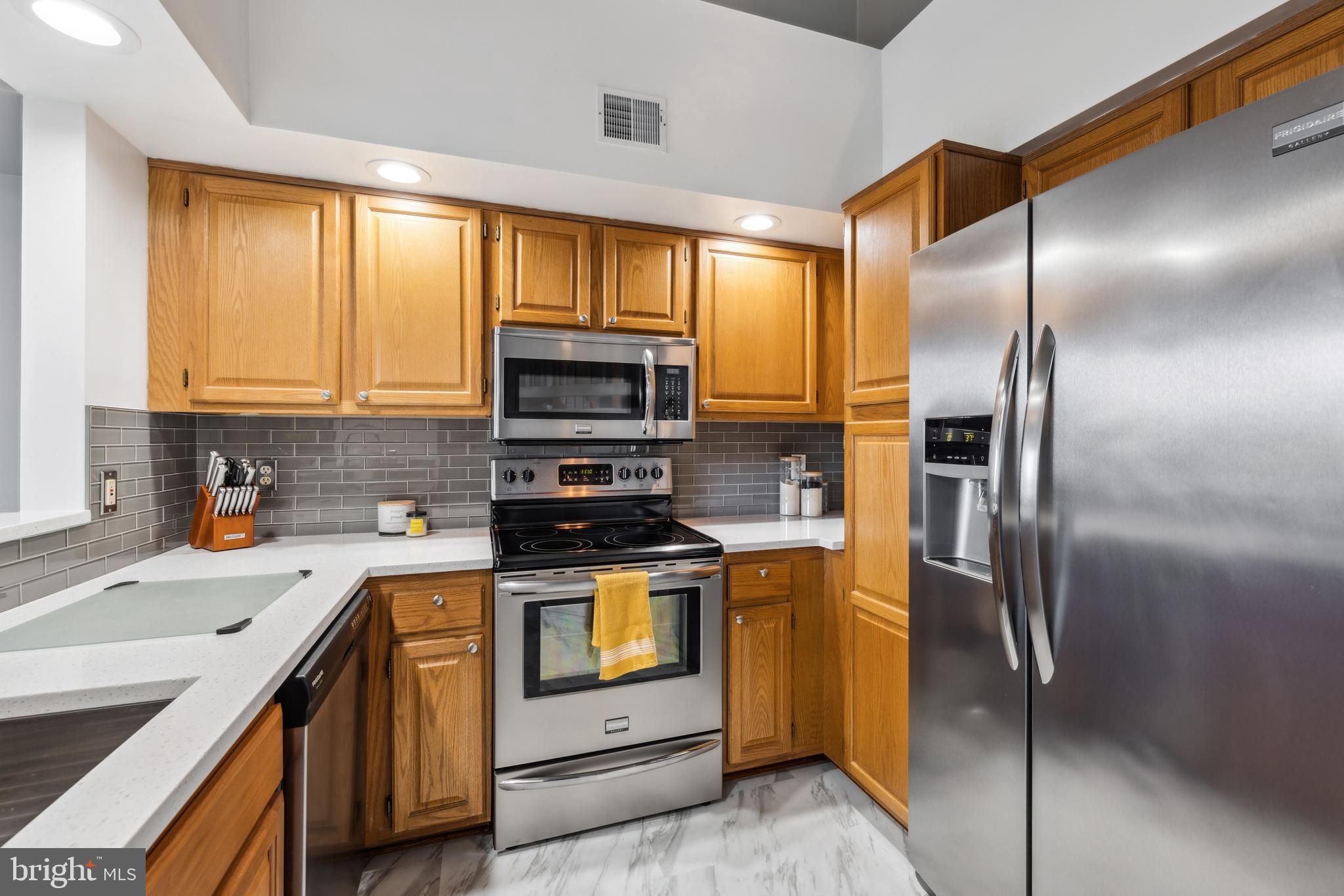 6934F Ellingham Circle Alexandria, VA 22315 - Photo 9 of 34 a kitchen with a refrigerator stove and sink