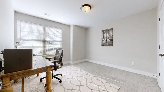 a view of a workspace with furniture and a window