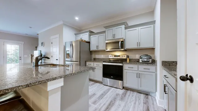 a kitchen with stainless steel appliances granite countertop a refrigerator sink and stove