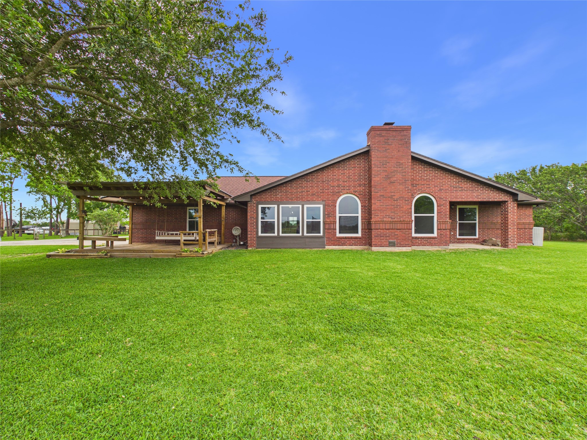 4610 Mustang Road Alvin, TX 77511 - Photo 42 of 50 View of the back of the home and the two patio areas. One off the garage/sunroom and the other off the primary suite.