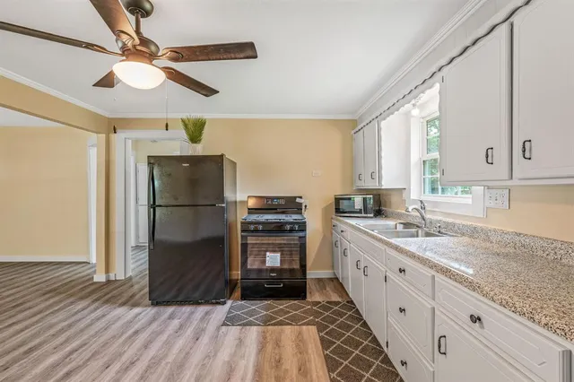 a kitchen with granite countertop a refrigerator and a sink