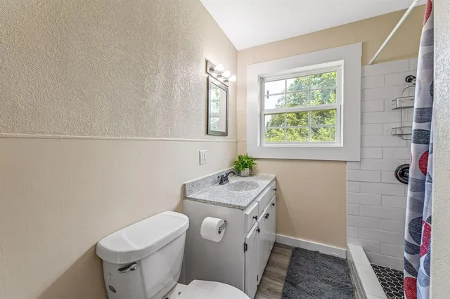 a bathroom with a toilet sink and mirror