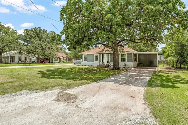 a front view of a house with a yard and trees