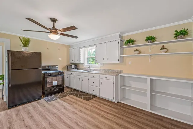 a kitchen with a refrigerator and white cabinets