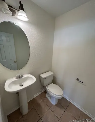 a bathroom with a sink toilet and mirror