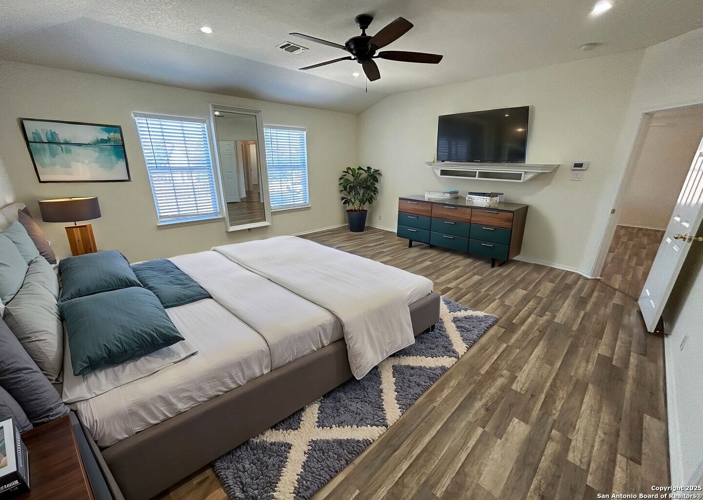 7714 Cold Mountain Converse, TX 78109 - Photo 16 of 27 a bedroom with a bed a television and wooden floor