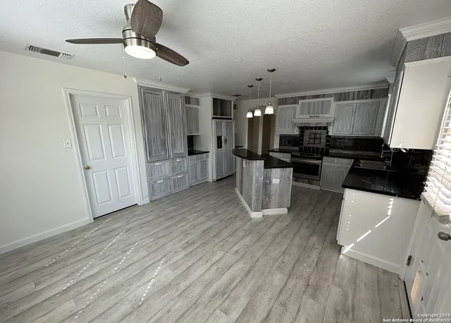 a kitchen with stainless steel appliances a refrigerator a stove a microwave and white cabinets