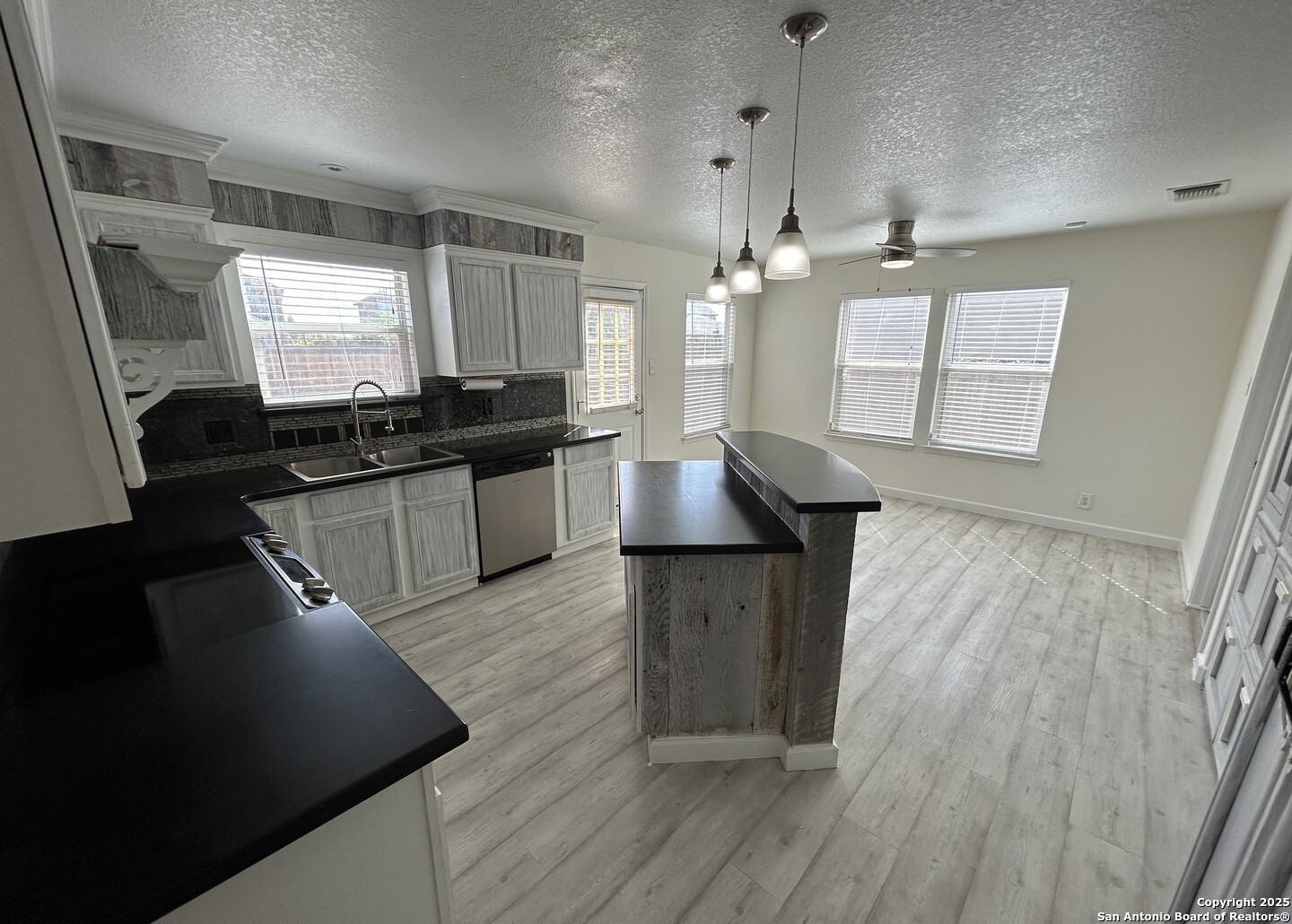 7714 Cold Mountain Converse, TX 78109 - Photo 9 of 27 a kitchen with granite countertop a stove a sink and a refrigerator