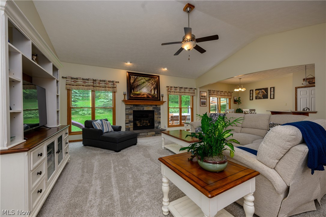 2664 Ridge Road Northwest Bolivar, OH 44612 - Photo 6 of 15 Carpeted living room with a healthy amount of sunlight, a fireplace, ceiling fan, and lofted ceiling
