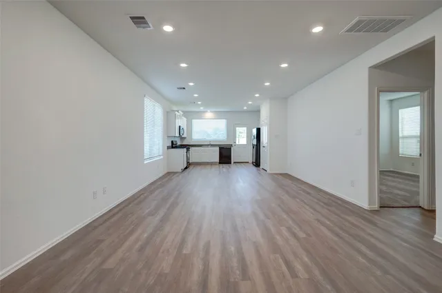a view of empty room with wooden floor