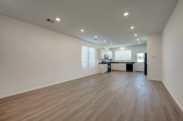 a view of kitchen with refrigerator sink and cabinets