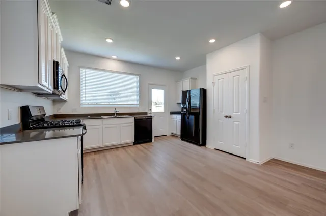 a kitchen with stainless steel appliances granite countertop a refrigerator and a sink