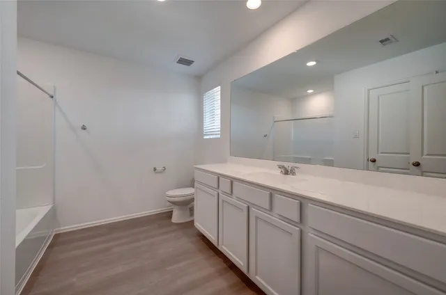 a bathroom with a tub shower and sink