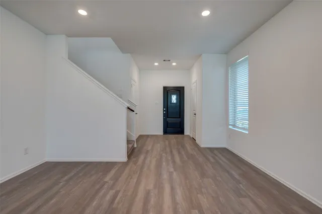 a view of an empty room with wooden floor