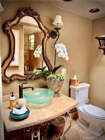 a bathroom with a granite countertop sink a toilet and a mirror