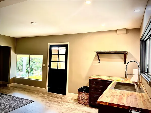 a view of a hallway with wooden floor and a bathroom