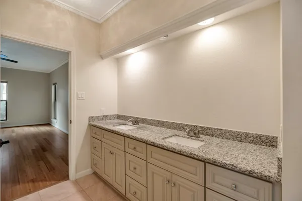 a bathroom with a granite countertop sink and white cabinets