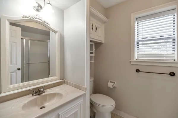 a bathroom with a granite countertop sink toilet and shower