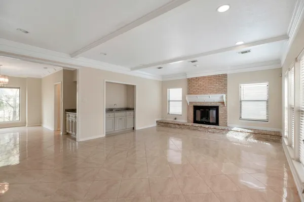 a view of an empty room with a fireplace and a window