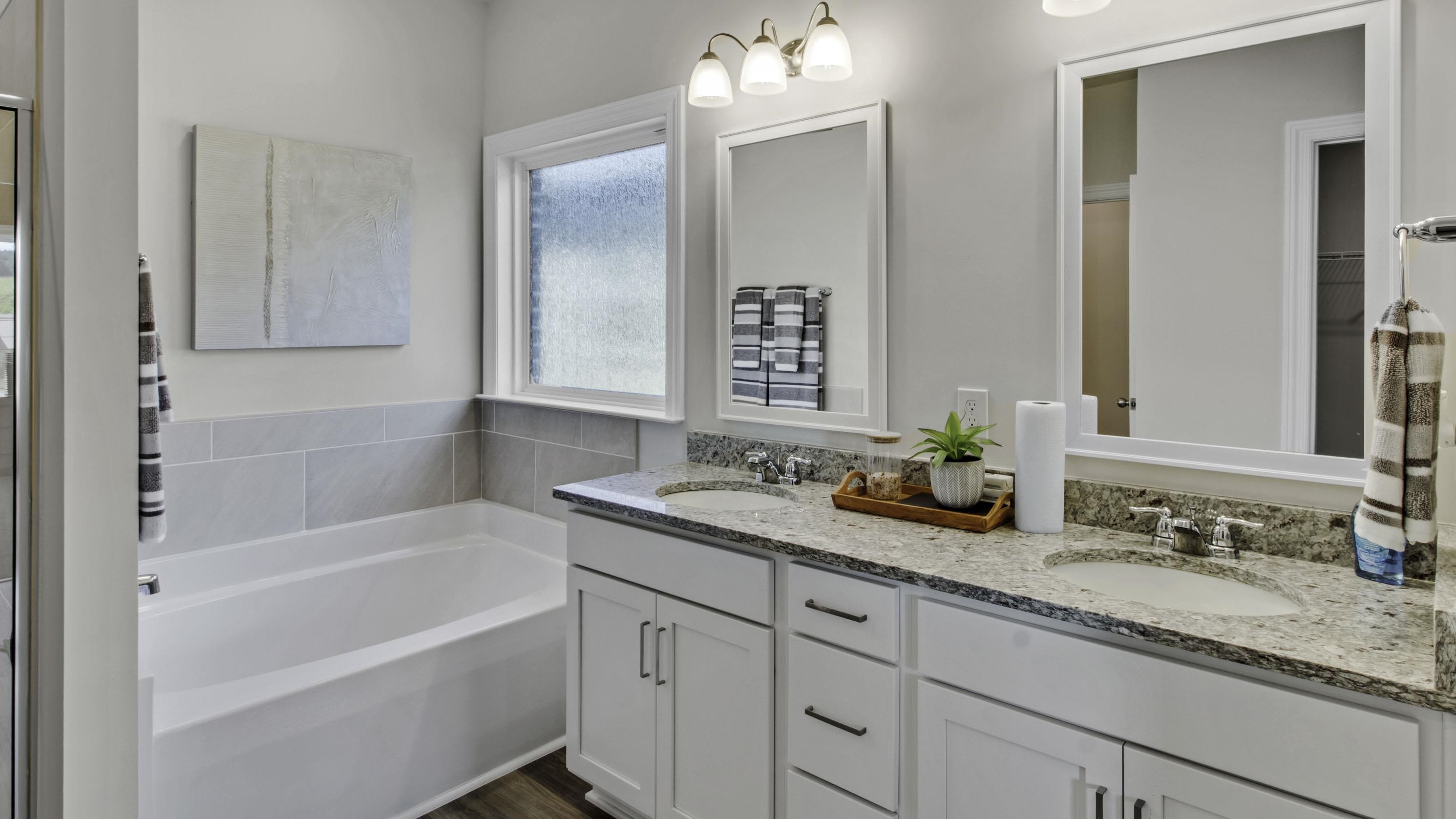 990 Mewborn Farm Road Oakland, TN 38060 - Photo 17 of 40 Full bath with double vanity, a garden tub, and dark wood finished floors