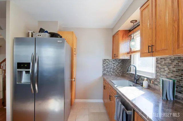 a kitchen with stainless steel appliances granite countertop a refrigerator a sink and a stove