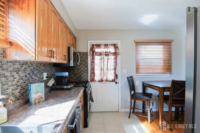 a kitchen with a table chairs and a window